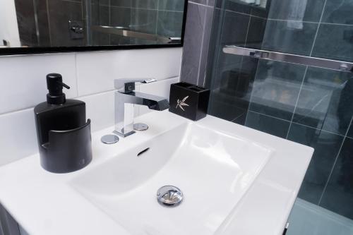 un lavabo con un dispensador de jabón negro. en Entire Superior 2-bedroom private suite, en Edmonton