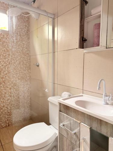 a bathroom with a toilet and a sink and a shower at Da Silva Chalé in Santa Lídia