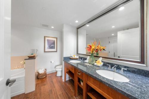 une salle de bain avec deux lavabos et un grand miroir dans l'établissement Honua Kai K1024 · HK K1024 Kaanapali Beach Condo Resort Living R, à Lahaina