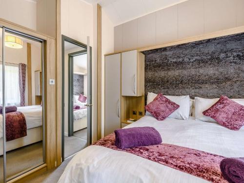 ニュー・ミルトンにある2 Bed in New Milton 89708の紫色の枕が付いた大きなベッドのある寝室