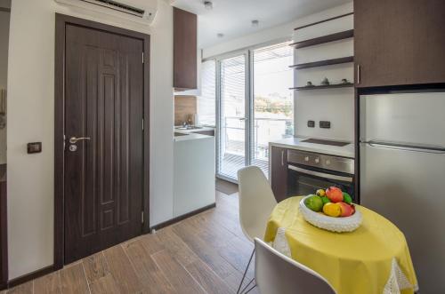 una cucina con tavolo e ciotola di frutta di City Apartments La Casa a Varna