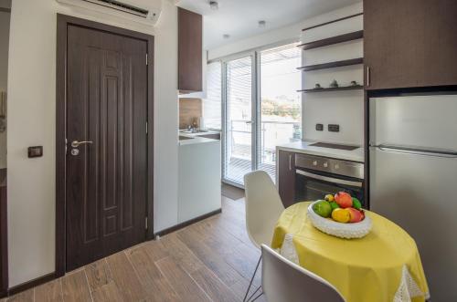 a kitchen with a table with a bowl of fruit on it at City Apartments La Casa in Varna City