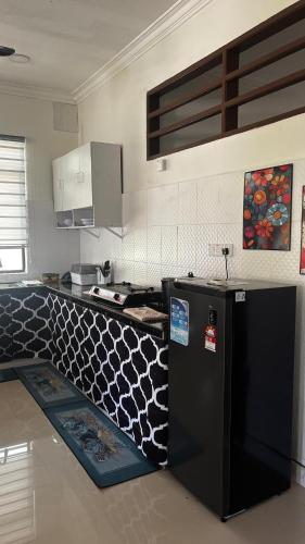 a kitchen with a black refrigerator and a counter top at Cwa Homestay in Kampong Molek