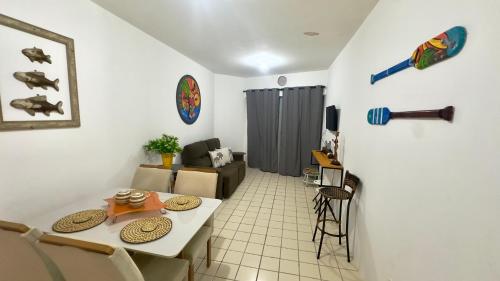 Una pequeña sala de estar con una mesa y sillas. en Flat Barra Beach, en Barra de São Miguel