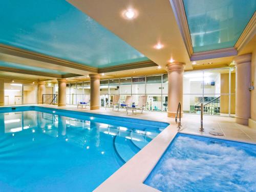 a swimming pool in a large building with a large ceiling at The Playford Adelaide - MGallery in Adelaide