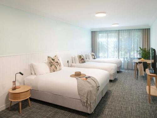 a hotel room with two beds and a couch at The Sebel Kiama in Kiama