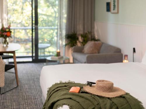 a bedroom with a bed with a hat on it at The Sebel Kiama in Kiama