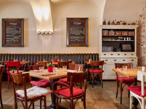 a restaurant with wooden tables and red chairs at PEST-BUDA Design Hotel in Budapest