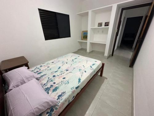 ein Schlafzimmer mit einem Bett und einem Fernseher darin in der Unterkunft Casa, Boqueirão Norte em Ilha Comprida- SP in Ilha Comprida