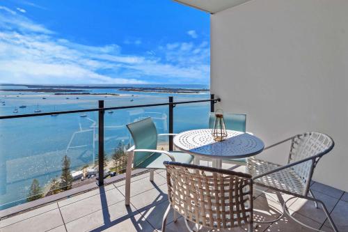 a table and chairs on a balcony with a view of the ocean at CASSA MQ - Oceanview 2BR Southport Gem Managed by The Cassa in Gold Coast