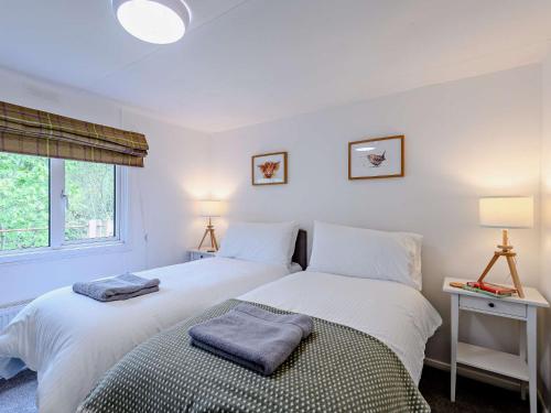 two beds in a white bedroom with two lamps at 2 Bed in Woodgreen 82875 in Godshill