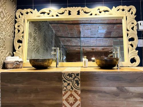 a bathroom with two sinks and a mirror at Hotel Santosi in San Luis Potosí