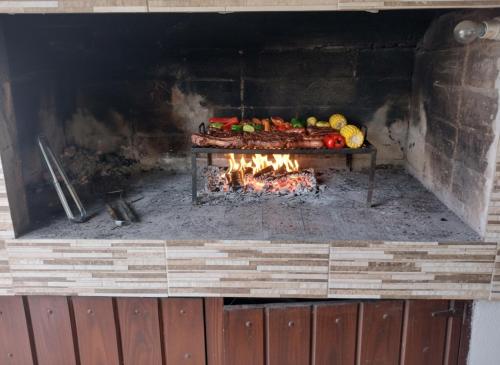 a fireplace with meat and vegetables in it at La Unión in Mar Azul