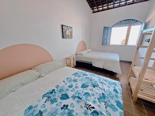 a bedroom with a bed and a ladder and a window at Blue house on blue beach in Pitimbú PB in Pitimbu
