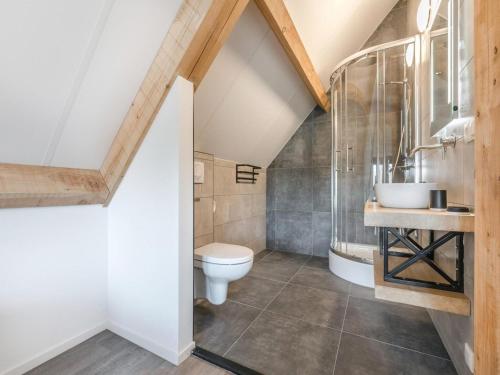 un baño con inodoro y lavabo en Modern bungalow in Baarle-Nassau with pond view, en Schaluinen