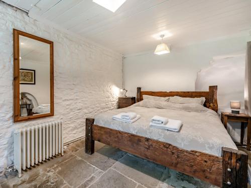 a bedroom with a large bed and a mirror at 3 Bed in Aberaeron 55308 in Ciliau-Aeron
