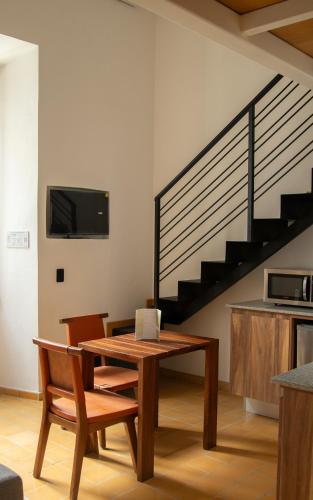 a living room with a table and chairs and a staircase at Calle y Número, López Cotilla in Guadalajara