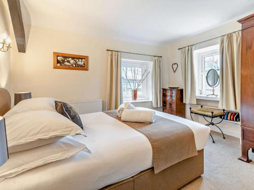 a bedroom with a large bed and two windows at 2 Bed in Cartmel LCC75 in Cartmel