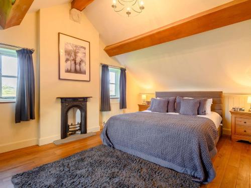 1 dormitorio con 1 cama y chimenea en 4 Bed in Blakeney 90589, en Awre