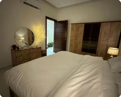 ハフル・アル・バティンにあるشقه وغرفه وصاله ومطبخ كامل هاديه عائليهの大きな白いベッドと鏡のある寝室