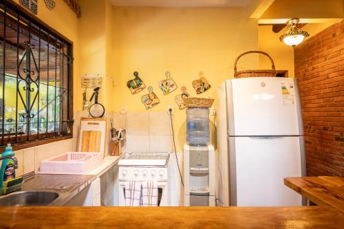 a kitchen with a white refrigerator and a sink at Casa Angi, con jardín y piscina en Sanber in San Bernardino