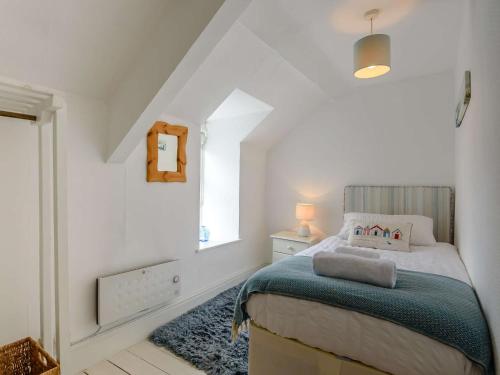 a white bedroom with a bed and a window at 2 Bed in Nefyn 44492 in Nefyn