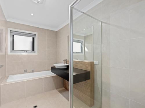 a bathroom with a shower and a sink and a tub at Time Out on Flinders in Indented Head