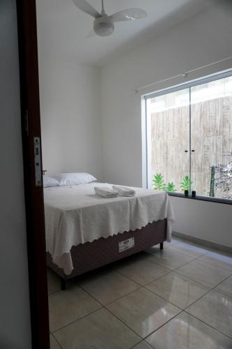 a white bedroom with a bed and a window at Apartamento Baixu 1 in Prado