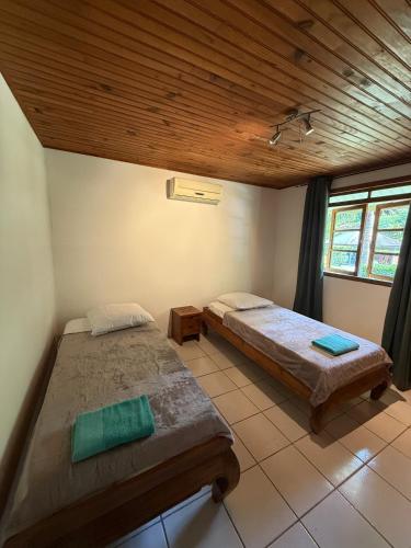 a bedroom with two beds and a wooden ceiling at Luna's Home Raiatea in Tiano