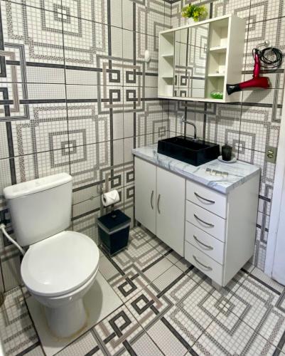 a bathroom with a toilet and a sink at Chalé Recanto dos Pássaros in Gramado
