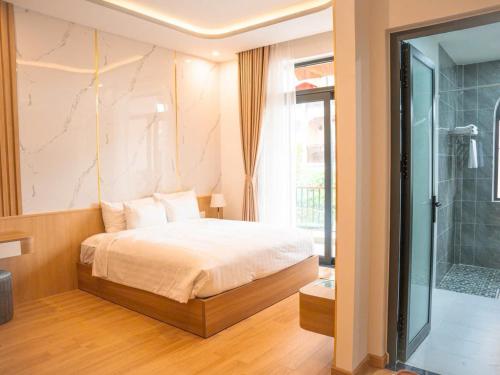 a bedroom with a bed and a glass shower at Ami Hoi An Home in Hoi An