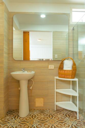 a bathroom with a sink and a mirror at Hotel Kartaxa in Cartagena de Indias