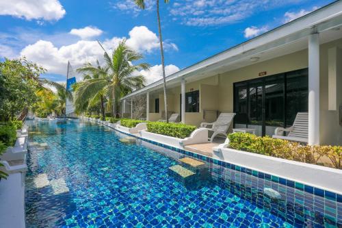 a swimming pool next to a house with a resort at Tuana Hotels Brook Pool Access in Chalong