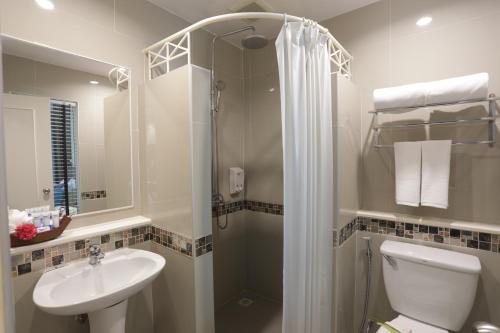 a bathroom with a shower and a toilet and a sink at Tuana Hotels Brook Pool Access in Chalong 
