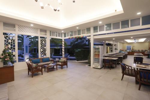 a lobby of a restaurant with tables and chairs at Tuana Hotels Brook Pool Access in Chalong