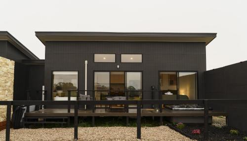 une maison noire avec un toit noir dans l'établissement Vineyard Villa, à McLaren Vale