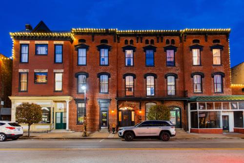 a large brick building with cars parked in front of it at The Woodford Hotel in Versailles