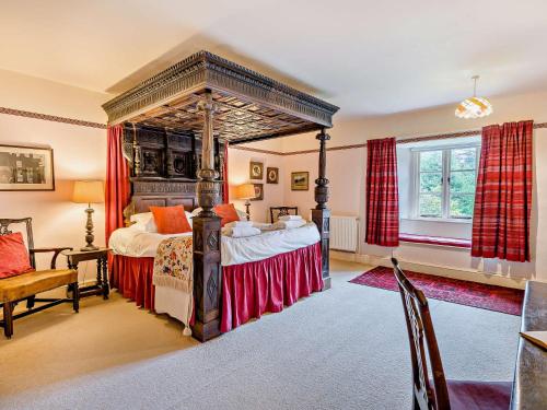 a bedroom with a four poster bed and red curtains at 4 Bed in Eskdale SZ158 in Eskdale