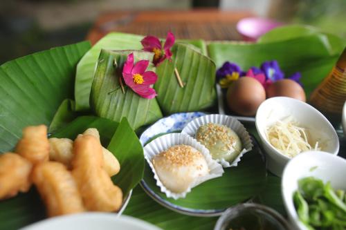 Ban Pak NamにあるBaan Chi Homestayの葉の上に食べ物を乗せた皿を置いたテーブル