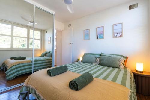 une chambre avec deux lits et un miroir dans l'établissement Freshwater Coastal Hideaway - 1 bedroom sleeps 4, à Sydney
