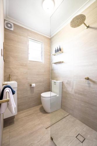 a bathroom with a toilet and a glass shower at Barossa Palms Motel in Nuriootpa