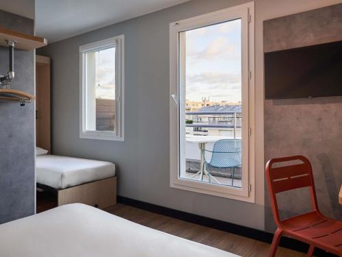 a room with a window and a table and a chair at ibis budget Issy Les Moulineaux Paris Ouest in Issy-les-Moulineaux
