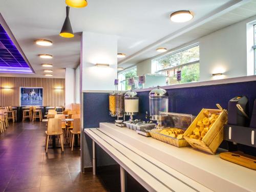 a restaurant with a counter with food on it at ibis budget Paris Porte De Montmartre in Paris