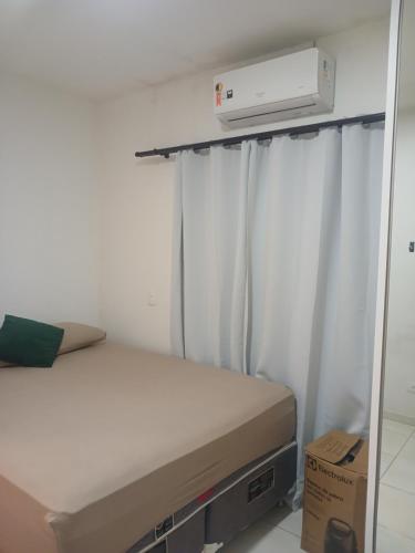 a small bedroom with a bed and a air conditioner at Recanto Dona Antônia in Piçarras