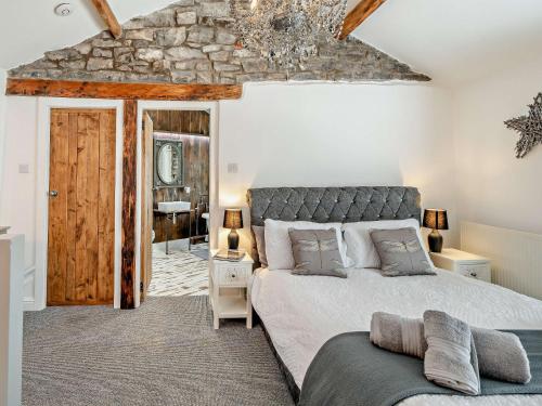 ケンダルにある1 Bed in Kendal 94210の石壁のベッドルーム1室(大型ベッド1台付)