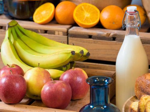 um grupo de bananas maçãs e laranjas e uma garrafa de leite em ibis budget Roissy CDG Paris Nord 2 em Roissy-en-France