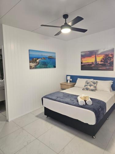 a bedroom with a bed and a ceiling fan at Villa La Sini Yeppoon in Yeppoon