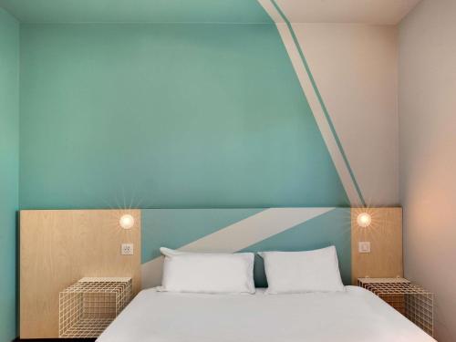a bedroom with a bed with two white pillows at Hotel Ibis Budget Montpellier Centre Millenaire - in Montpellier