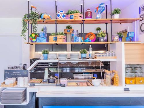 ヴィラ・ノヴァ・デ・ガイアにあるHotel ibis Budget Porto Gaiaの皿や皿が並ぶキッチン