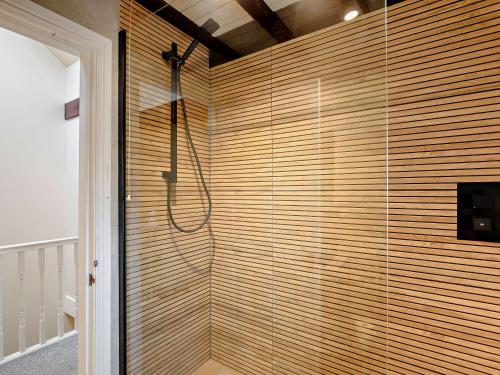 ein Bad mit einer Dusche und einer Holzwand in der Unterkunft 3 Bed in Bowness-On-Windermere 93088 in Bowness-on-Windermere